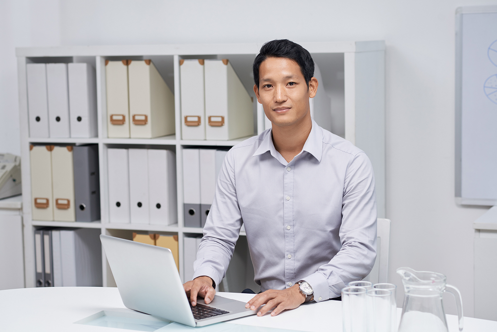 Young offshore professional working confidently at their desk